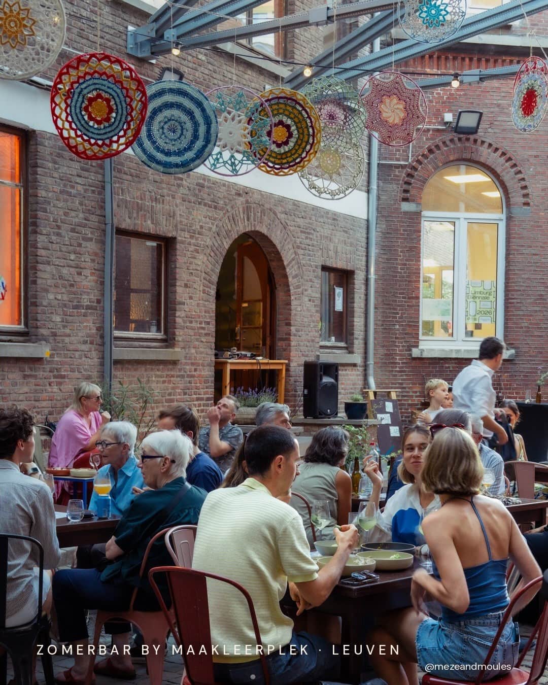 Bezoekers aan tafel op het binnenplein tijdens de zomerbar